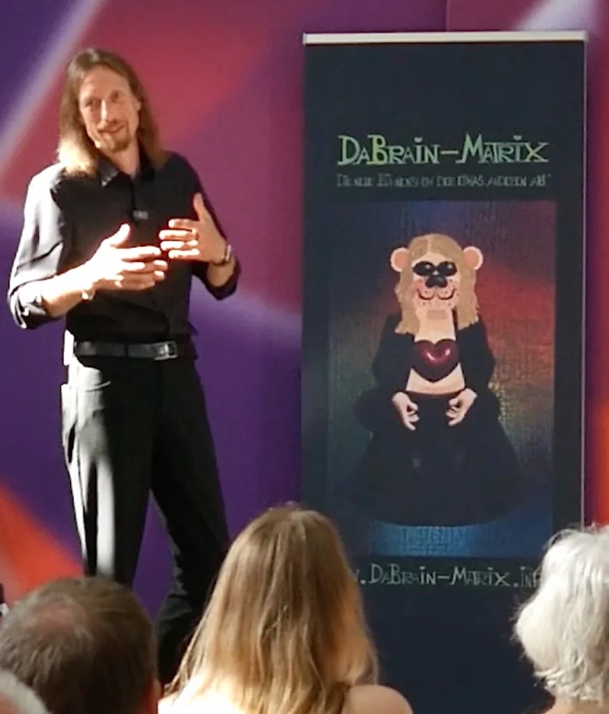 Lars Mährholz spricht auf einer Bühne vor Publikum.